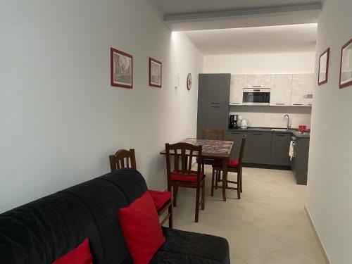 ein Wohnzimmer mit einer Couch und einem Tisch mit Stühlen in der Unterkunft Case Rossa e Blu in Villanova dʼAlbenga