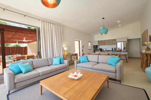 a living room with two couches and a table at Moorea Beach Villas in Haapiti