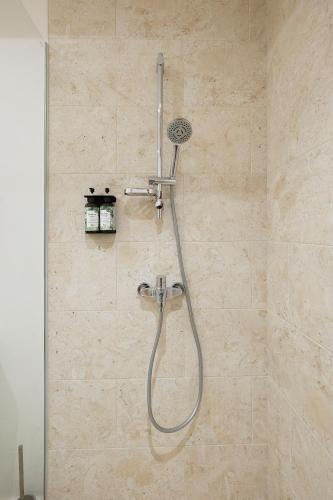 a shower with a shower head in a bathroom at Moorea Beach Villas in Haapiti
