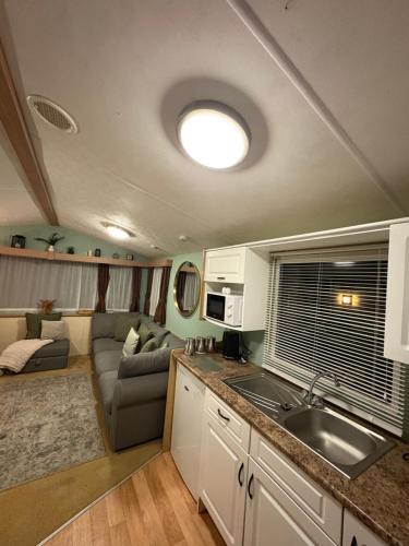 a kitchen and a living room with a couch at Slaley Forest Hexham Caravan Retreat Pet Friendly - sleeps 6 in Slaley