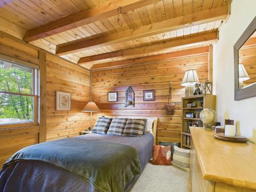 a bedroom with wooden walls and a bed in a room at Top of the Line Asheville Mountain Cabin in Leicester
