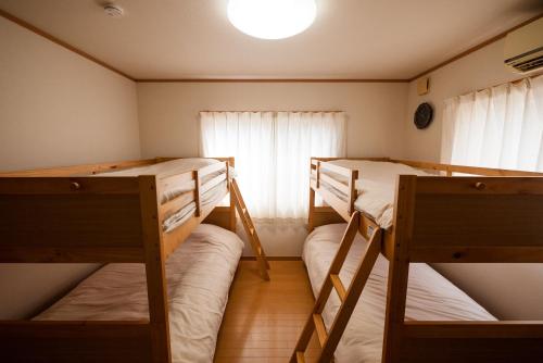 a room with two bunk beds and a window at ゆるりたび in Toyama