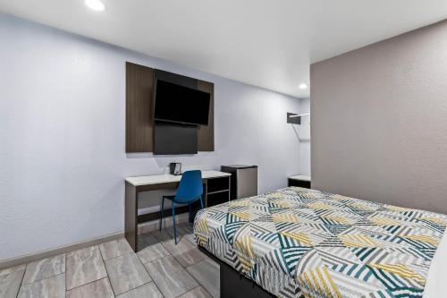 a bedroom with a bed and a desk and a tv at Motel 6-Murfreesboro, TN in Murfreesboro