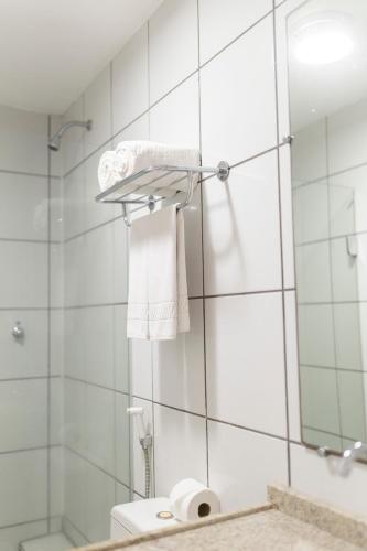 a bathroom with a shower and a toilet and a mirror at Gran Lençóis Flat Residence in Barreirinhas