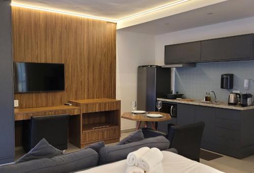 a living room with a couch and a kitchen at Blend Coliving One - 2a in Ribeirão Preto
