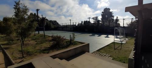 an empty tennis court with a basketball hoop on it at Lindo y cómodo departamento en Algarrobo, Chile in Algarrobo