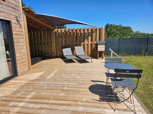 a patio with two chairs and a table and a fence at Tiny House avec Spa privatif in Boigny-sur Bionne