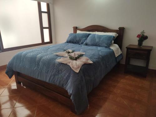 ein Schlafzimmer mit einem Bett mit zwei Blumen drauf in der Unterkunft Casa Encanto in Villa de Leyva