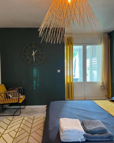 een slaapkamer met een bed en een klok aan de muur bij Les pieds dans l'eau in Baie Nettle