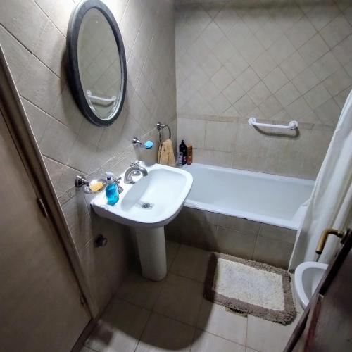 a bathroom with a sink and a tub and a mirror at Bella y cómoda in Santa Rosa
