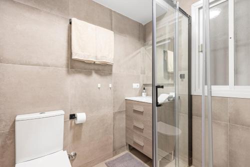 a bathroom with a toilet and a glass shower at The loving hummingbird in Mijas Costa