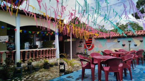 a group of pink tables and chairs in front of a building at Hostel Casa Grande de Outeiro in Belém