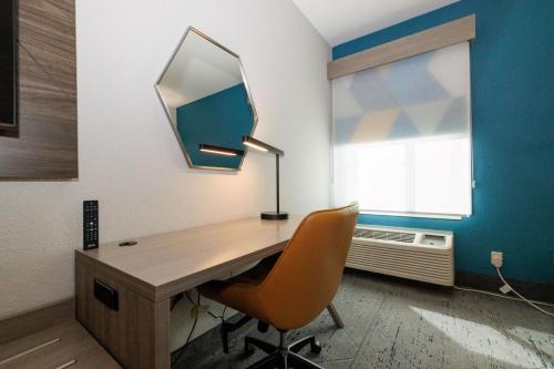 a desk with a lamp and a chair in a room at Holiday Inn Express Berkeley by IHG in Berkeley