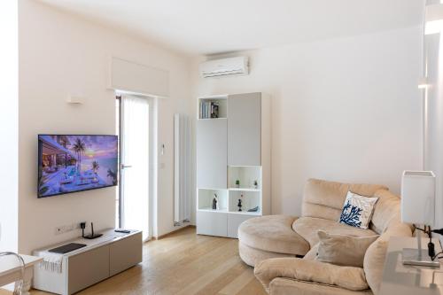 a white living room with a couch and a tv at Domus Portofino - Relax & Live the Italian Riviera in Santa Margherita Ligure