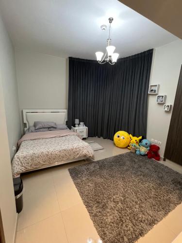 a bedroom with a bed and two stuffed animals on the floor at Hotel apartment in Sharjah
