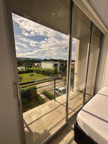 a bedroom with a bed and a view of a balcony at Casa quinta Aluna in Carmen de Apicalá
