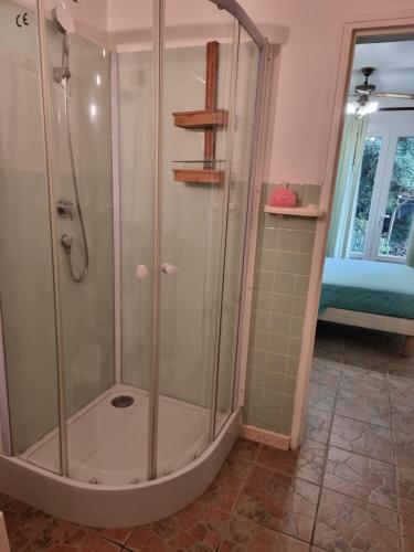 a shower with a glass enclosure in a bathroom at Chambre avec salle de bain in Penta-di-Casinca