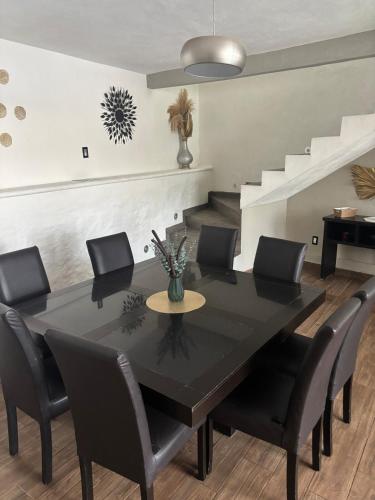 a dining room with a black table and black chairs at Casa con alberca en Jiutepec in Jiutepec