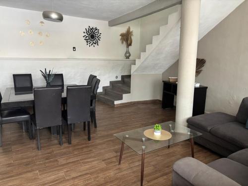 a living room with a table and chairs and a staircase at Casa con alberca en Jiutepec in Jiutepec