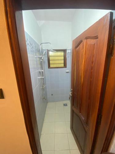 un bagno con cabina doccia e porta di Lafia Housse a Cotonou
