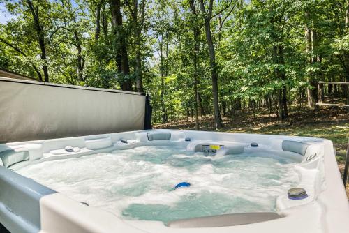 a jacuzzi tub in the middle of the woods at Cozy Retreat - Sauna Hot Tub & Game Room in VA in McGaheysville