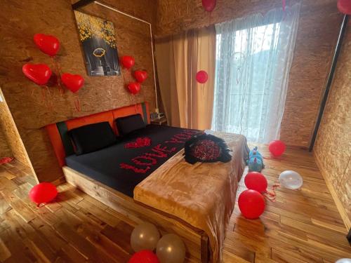 a bedroom with red balloons on the floor and a bed at HOMESTAY ĐỐM HOUSE in Hoat