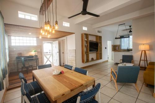 a dining room and living room with a wooden table and chairs at Treetops Hotel in Caye Caulker