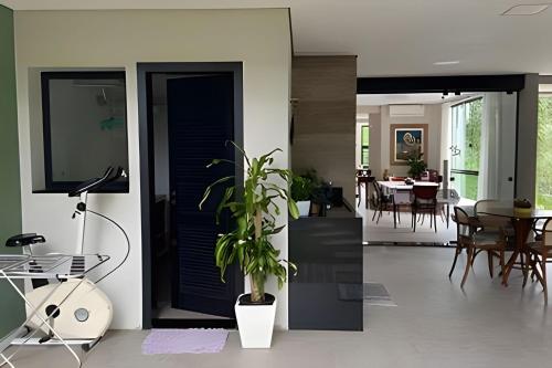 a living room with a blue door and a dining room at Casa Dani · CURTA! |143| Aconchegante Casa 3 suíte in Joinville