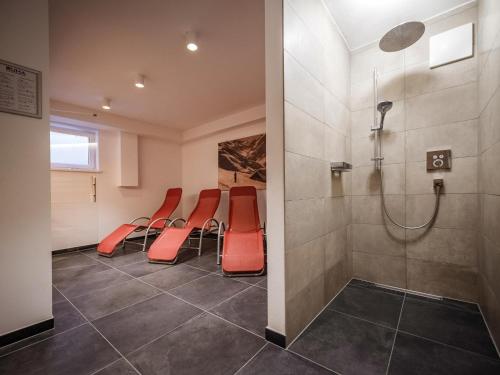 a waiting room with red chairs and a shower at Lodge Amanda-Elise in Vorderkrimml