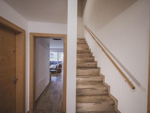a staircase in a house with white walls and wooden floors at Lodge Amanda-Elise in Vorderkrimml