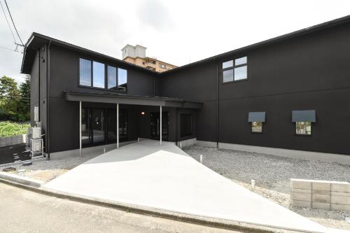 a black building with a ramp in front of it at Hotel Yatsu in Komatsu