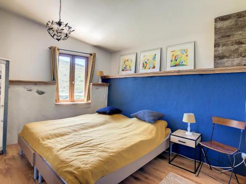 a bedroom with a bed and a blue wall at Oleandre in Cassagnolles