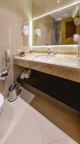 a bathroom with a sink and a toilet and a mirror at Gabala Karvansaray Hotel in Gabala