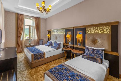 a hotel room with two beds and a couch at Gabala Karvansaray Hotel in Gabala