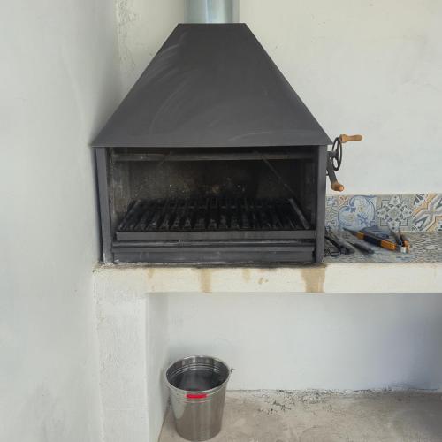 a black grill with a bucket on a wall at Casa Rural Mayne in Villafranca de los Caballeros