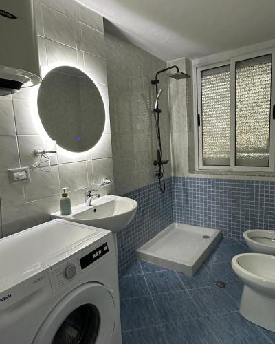 a bathroom with a washing machine and a sink at S&E apartments in Tirana