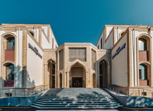 a building with stairs in front of it at Gabala Karvansaray Hotel in Gabala