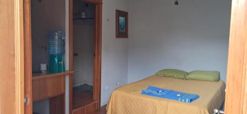 a bedroom with a bed with a blue shirt on it at Residencias Los Hasses in Santiago Atitlán