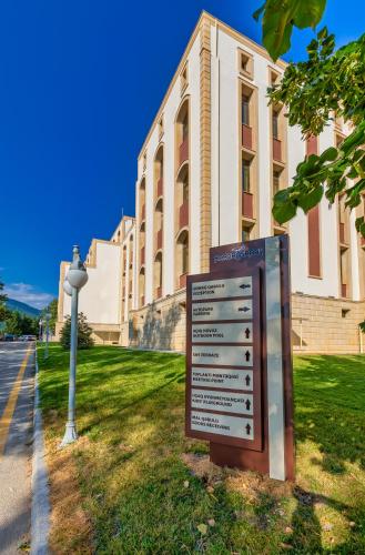 a sign in the grass in front of a building at Gabala Karvansaray Hotel in Gabala