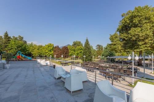 a patio with tables and chairs and a playground at Gabala Karvansaray Hotel in Gabala