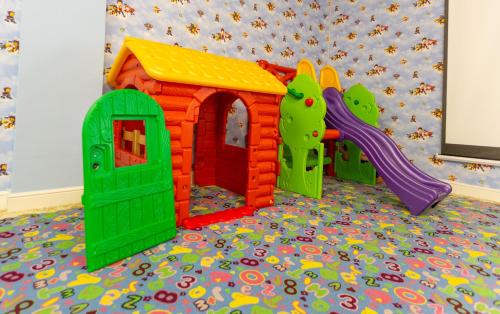 a childs play room with a toy house and a slide at Gabala Karvansaray Hotel in Gabala