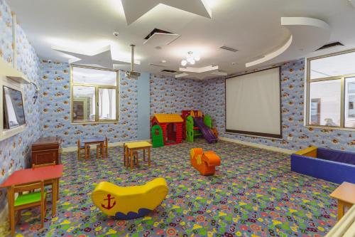 a childrens play room with chairs and a screen at Gabala Karvansaray Hotel in Gabala