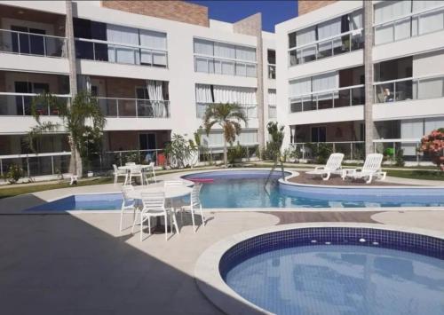 a swimming pool with a table and chairs next to a building at varandasdofrancesapt216 Praia do Frances in Praia do Frances