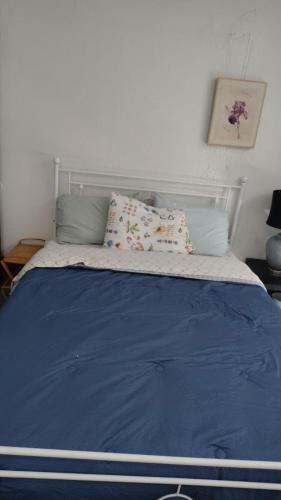 a bed with blue sheets and pillows in a bedroom at Valley and city views in Steubenville
