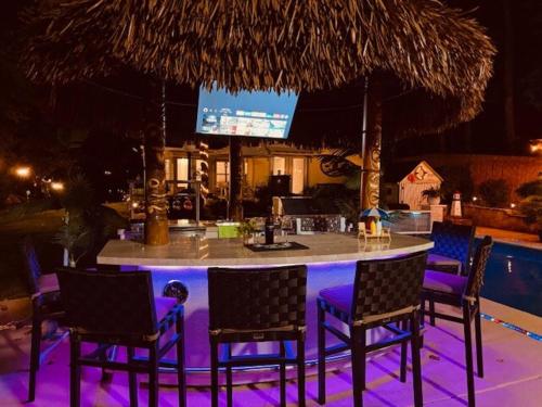 a bar with chairs and a table with purple lighting at Paradise Oasis in Duluth