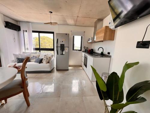 a living room with a white couch and a kitchen at Departamento con Jacuzzi en Pinamar Centro in Pinamar
