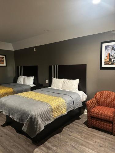 ヒューストンにあるRegency Innのベッド2台と椅子があるホテルの部屋