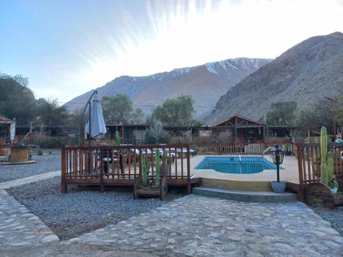 a resort with a pool and a table and an umbrella at Casa Refugio en Rivadavia in Vicuña