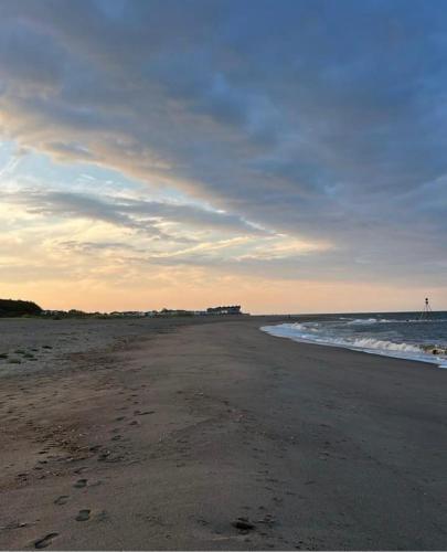 a beach with footprints in the sand and the ocean at GNDJ Hotel Skegness in Skegness