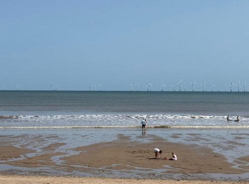 a group of people playing in the sand at the beach at GNDJ Hotel Skegness in Skegness